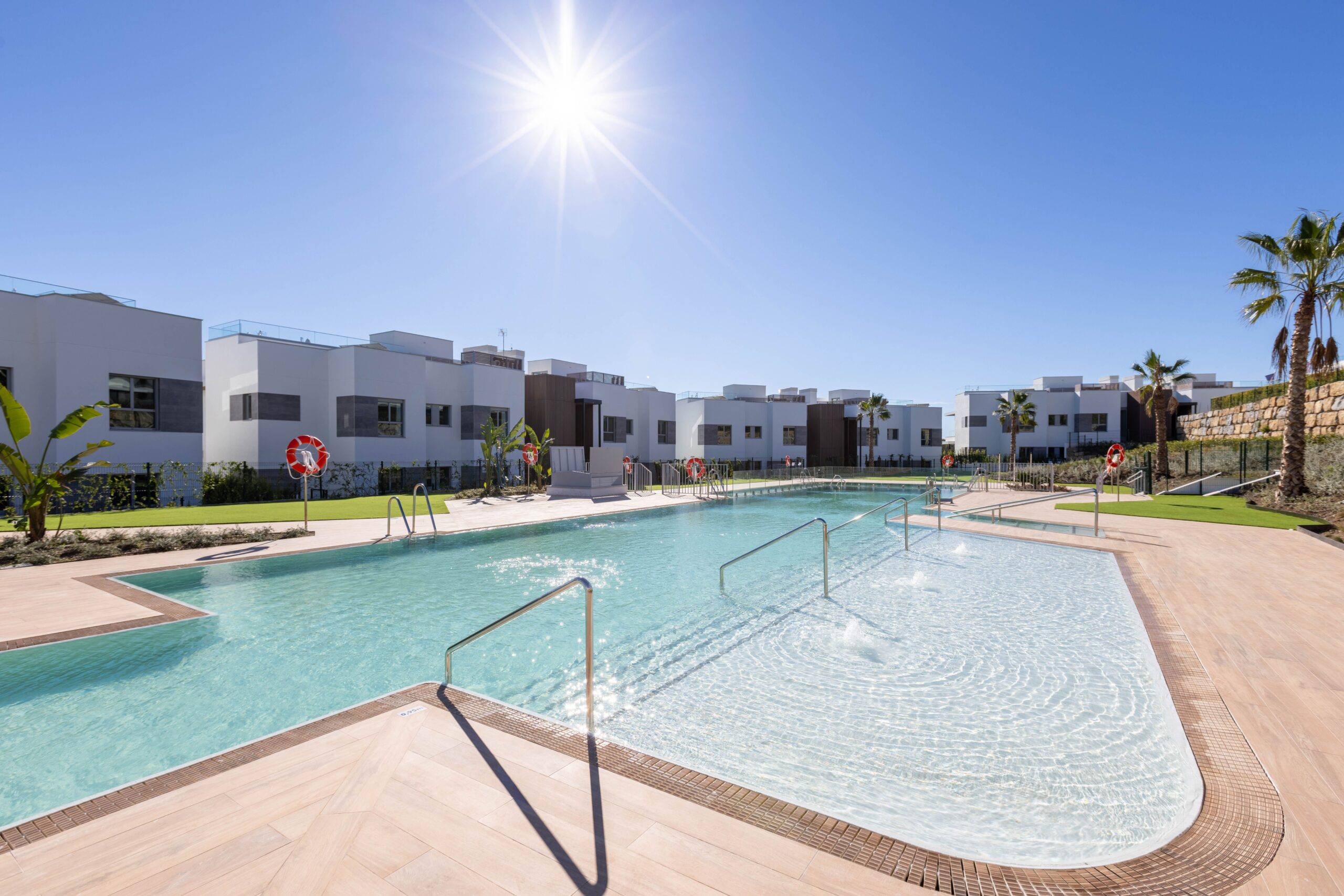 Gemeinschaftspool mit Solarium und Palmen